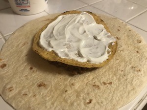 Spread sour cream over the tostada shell